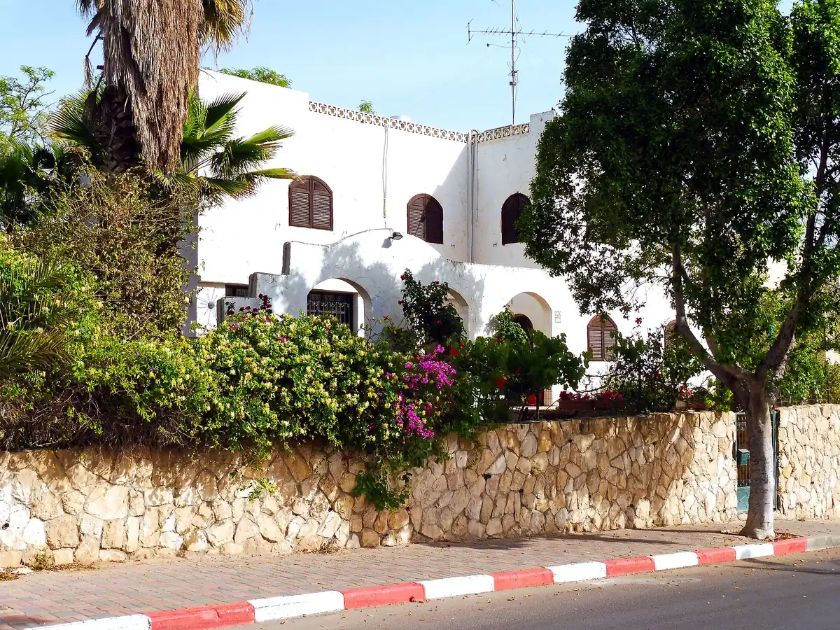 A white house with a garden wall on HaMitzadim St